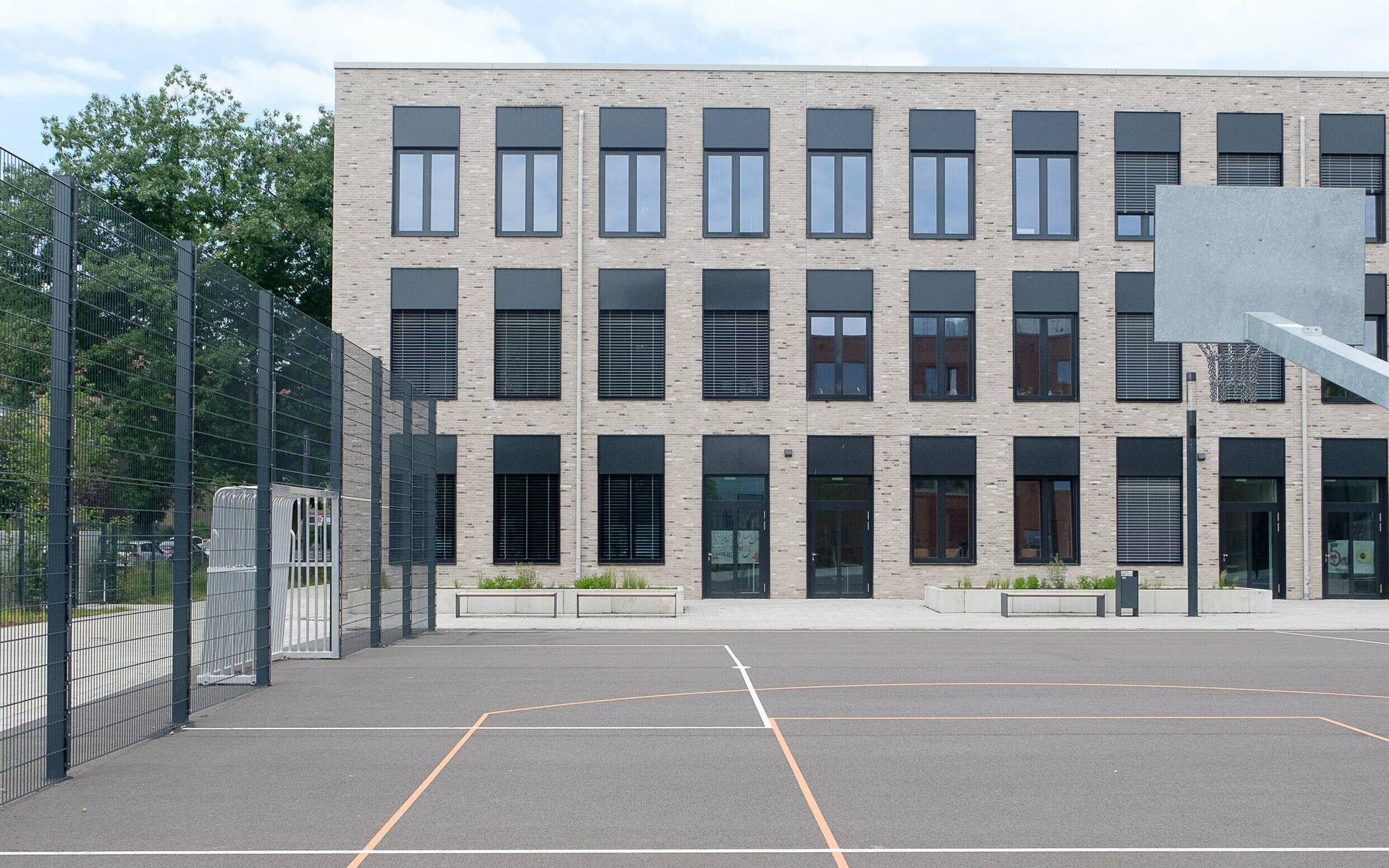  Auf dem Schulhof finden sich eine moderne Calisthenics-Anlage, ein Basketballfeld und ein Soccer-Platz.  