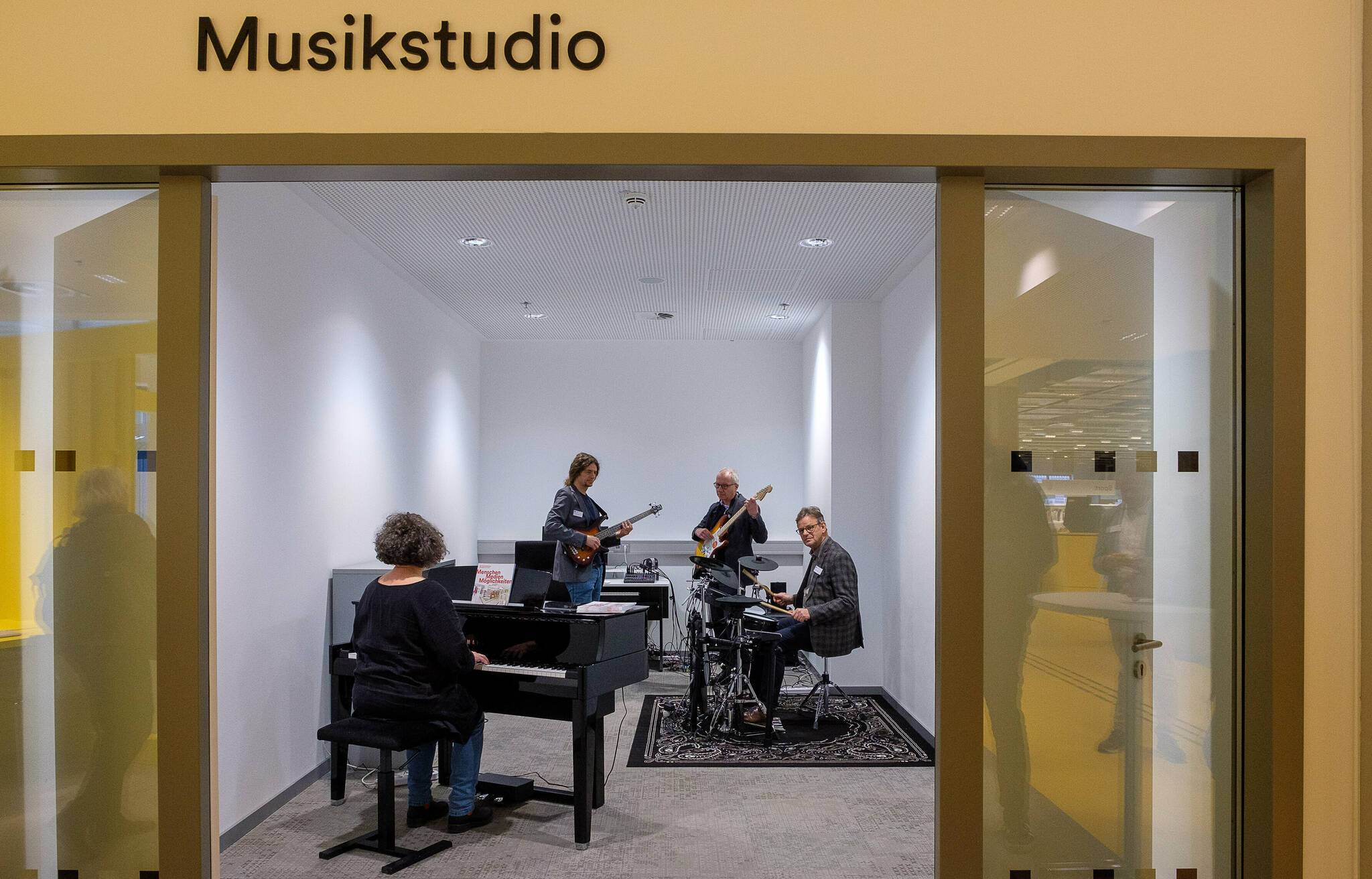 Das neue Musikstudio in der Zentralbibliothek mit einem hybriden Flügel, einer E-Gitarre, einem E-Bass und einem E-Drum-Set.