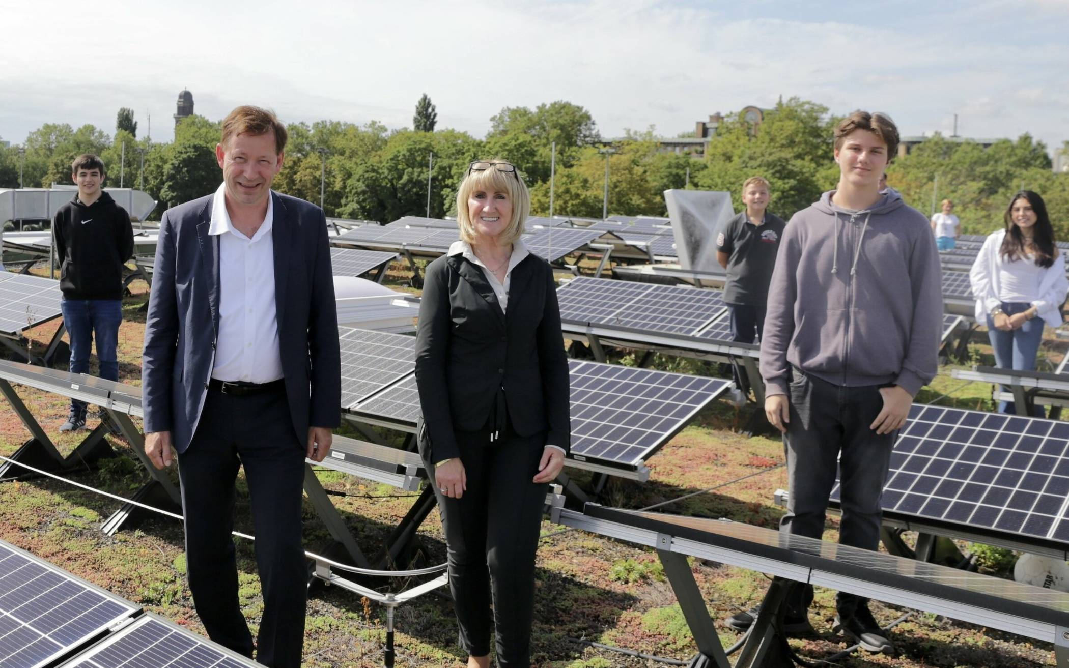 Die Carl-Benz-Realschule ist bereits mit einer Photovoltaikanlage ausgestattet: Stadtdirektor Burkhard Hintzsche und Schulleiterin Bettina Peiffer mit Schülerinnen und Schülern auf dem Dach des Gebäudes an der Lewitstraße.