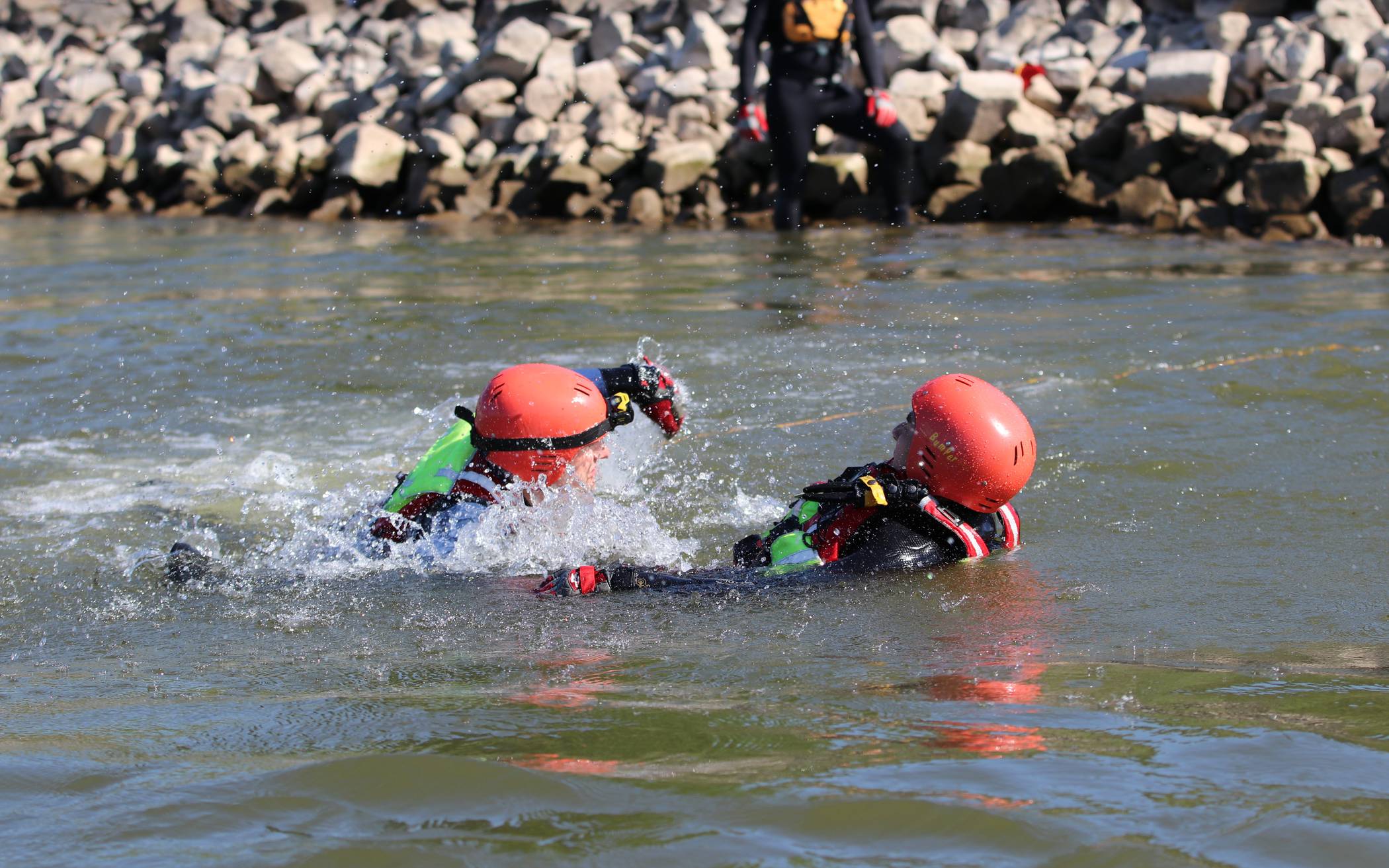  Bei einer Übung im Rhein schwimmt ein Strömungsretter (links) der Taucherstaffel zu der in Not geratenen Person, um diese so schnell wie möglich zu sichern und ein Untergehen zu verhindern. 
