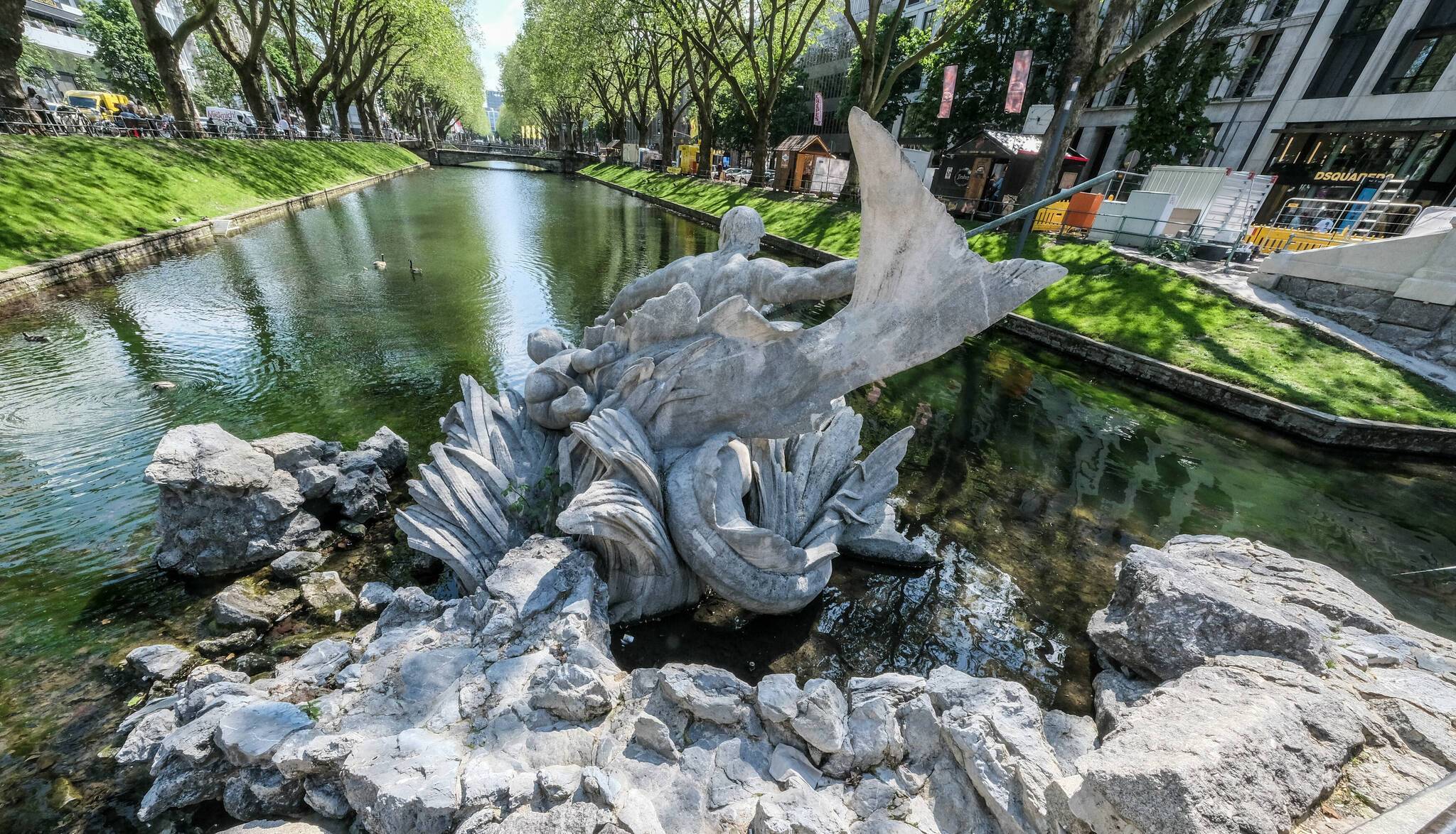  Das Wasserspiel wurde zwischen 1898 und 1902 geschaffen. Seinen Namen verdankt der Brunnen dem griechischen Meeresgott Triton, der mit einer Lanze bewaffnet die größte Skulptur des Brunnens ist. 