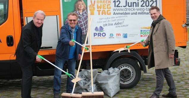  Gruppenbild vor Dame (v. l): AWISTA-Chef Jörg Mühlen, Dr. Klaus Vorgang, Pro Düsseldorf-Vorstand, und Sascha Maas, Geschäftsführer der Deutschen Postcode Lotterie, vor dem Plakat mit WDR-Moderatorin Petra Albrecht, die im Jahr 2021 „Gesicht“ des Dreck-weg-Tages ist. 