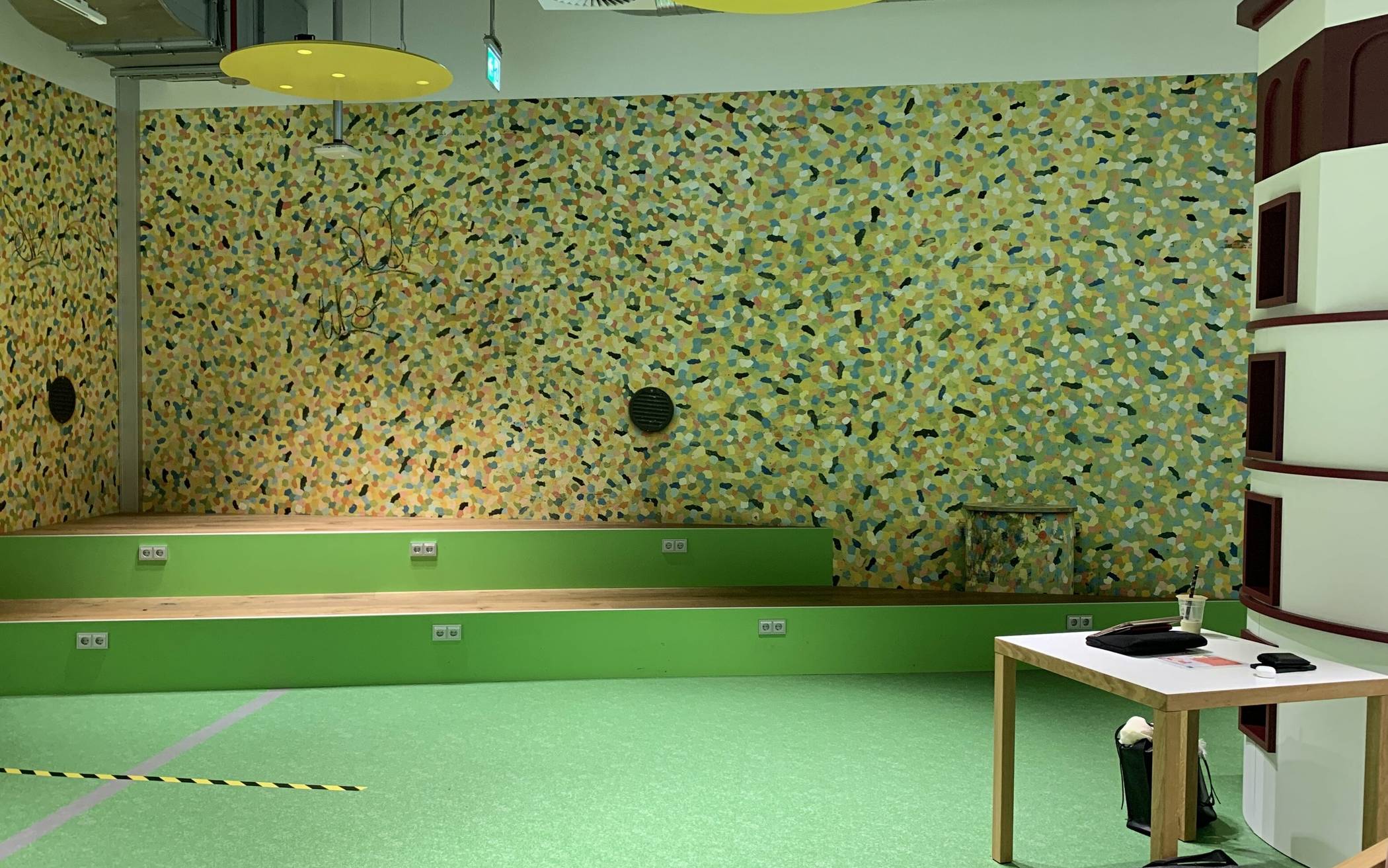 Die Wand hinter der Sitzstufenanlage in der Kinderbibliothek wurde gestalterisch an die große Treppe am Burgplatz angelehnt und sorgt mit der Nachbildung des Kunstwerks „Rivertime“ von Prof. Hermann-Josef Kuhna für ein Stück Düsseldorfer Heimat.