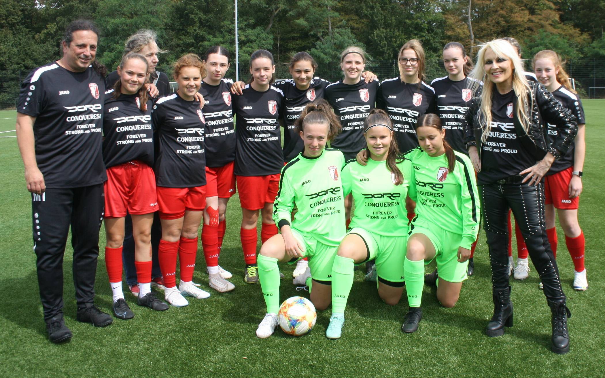 Rockige Trikotsponsorin Doro (r.) mit den U17-Spielerinnen der TUSA und Coach Marcus Italiani (l.) sowie in Lederkluft im Ballbesitz (kleines Bild unten).