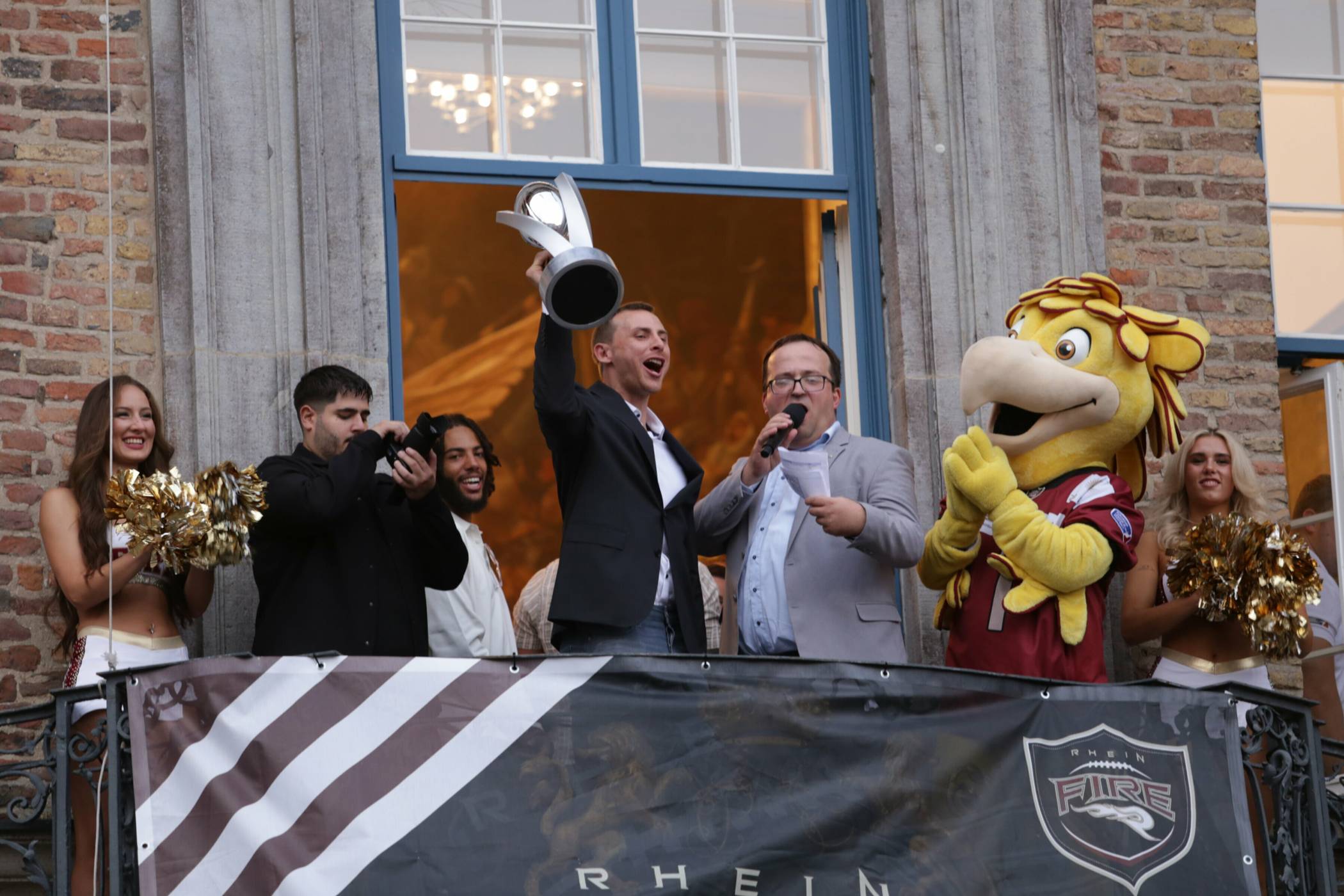 Rhein Fire-Quarterback Jadrian Clark präsentiert den Düsseldorfer Footballfans die begehrte ELF-Trophäe auf dem Rathausbalkon.