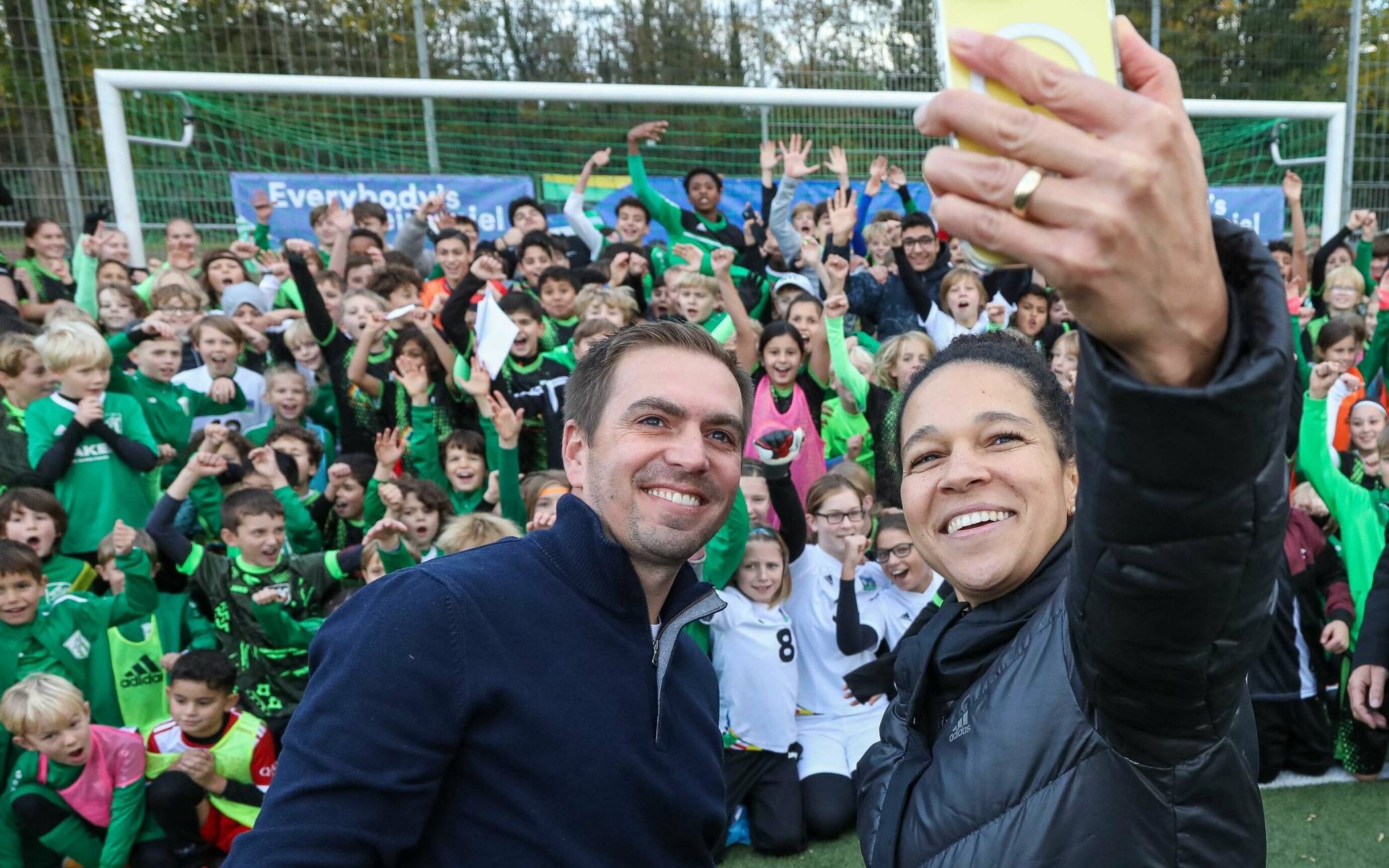 Einmal lächeln bitte! EM-Turnierchef Philipp Lahm und Botschafterin Célia Šašić beim Selfie mit den Kindern des SV Wersten 04. Die Kids löcherten die Sport-Prominenz mit Fragen, feuerten beim Elferschießen an, dass Lahm gegen OB Stephan Keller gewann. Die Werstener Sportanlage am Dechenweg erhält einen neuen Kunstrasenplatz. Vier weitere Vereinsgelände in der Stadt werden im Zuge der EM modernisiert (der Düsseldorfer Anzeiger berichtete).