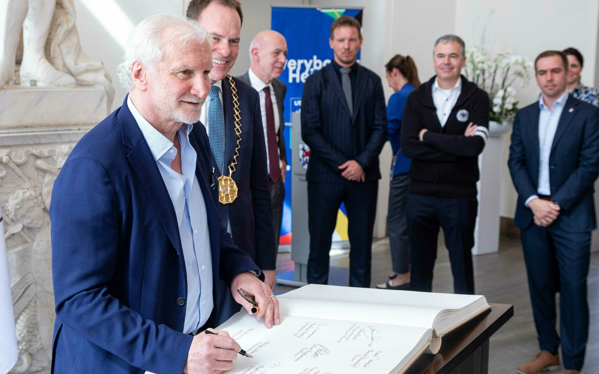 Rudi Völler, Weltmeister von 1990 als Spieler und Vizeweltmeister 2002 als Trainer, hatte in der Woche besonders viel zu unterschreiben: Hier der Eintrag ins Goldene Buch der Stadt neben OB Stephan Keller. Im Hintergrund (v. l.): DFB-Präsident Bernd Neuendorf, Bundestrainer Julian Nagelsmann, DFB-Sportgeschäftsführer Andreas Rettig und Turnierdirektor Philipp Lahm.