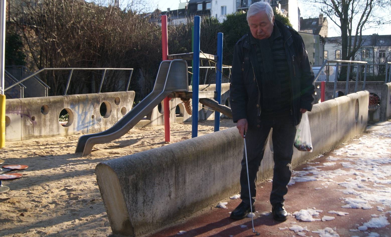 Kronkorkensammler Gerhard Steinbach mit Magnetstab auf dem Spielplatz an der Flurstraße.