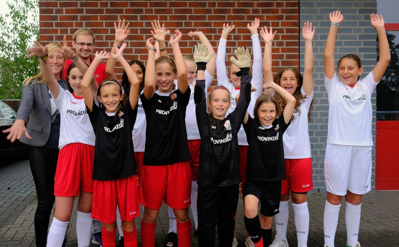  Die Leiterinnen Melanie Dornbusch und Sven Kienert (h. l.) sowie die Fußballerinnen des neuen Mädchen-Leistungszentrums der TuSA freuen sich über materielle Unterstützung von außen. 