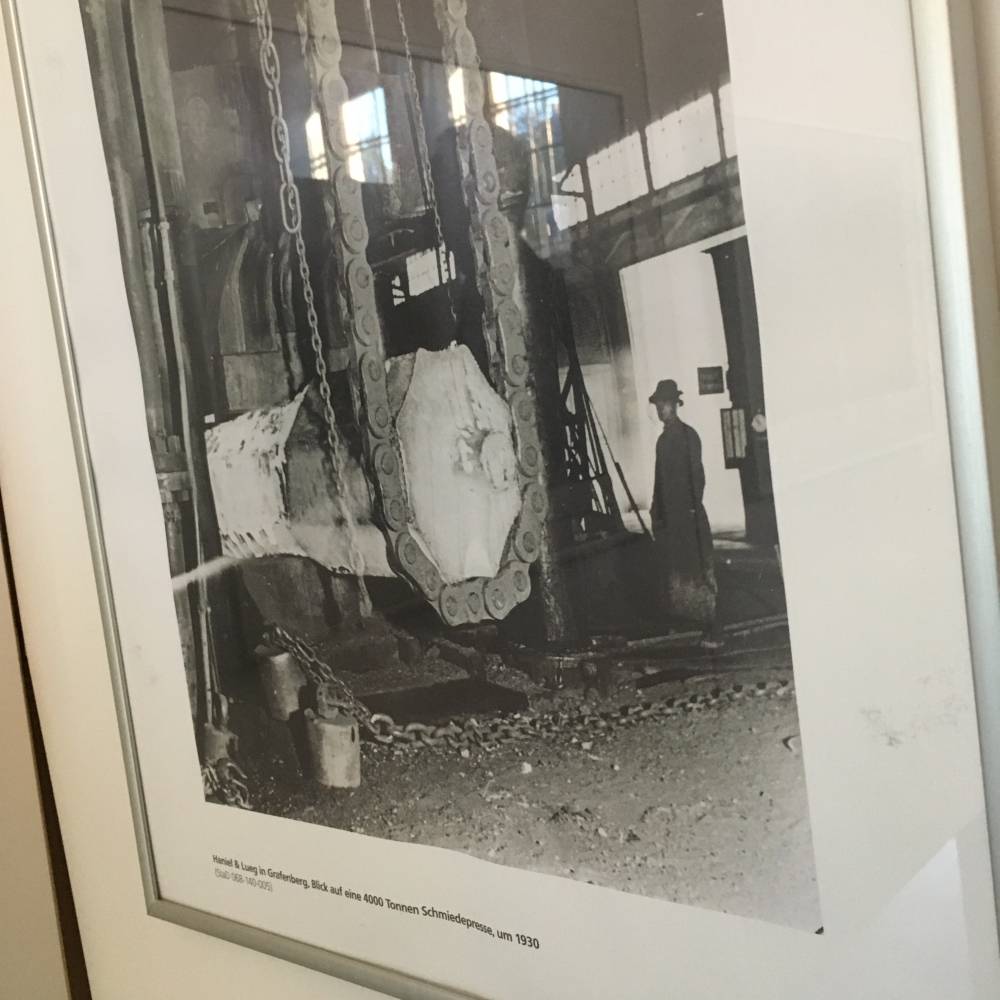  Foto von einem Arbeiter vor einer 4000-Tonnen-Presse in Grafenberg. 