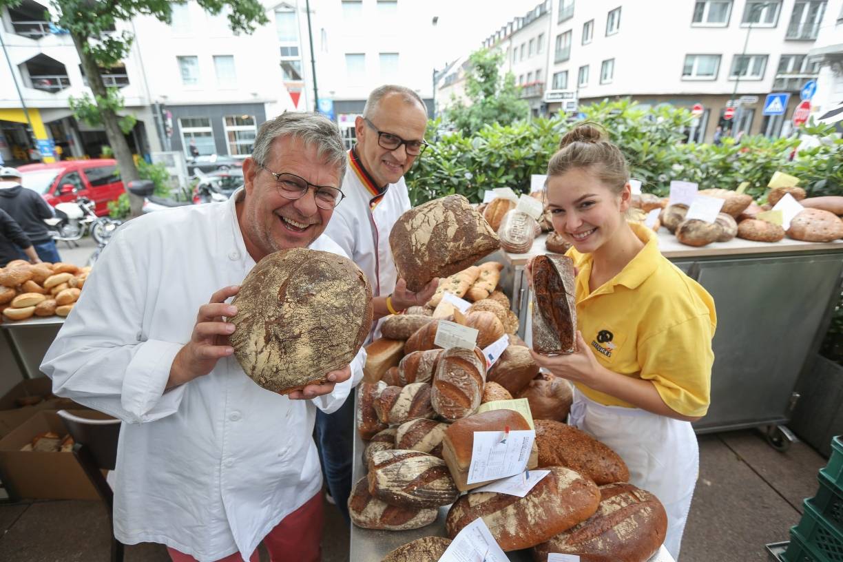 Karl-Ernst Schmalz (Mitte) prüft Brote und Brötchen der Düsseldorfer Handwerksbäcker auf dem Carlsplatz. „Das machen wir öffentlich, damit jeder sehen kann, wer hinter den Produkten steht“, sagt Thomas Puppe. Mit Sophie Hinkel rückt auch schon die nächste Generation bei den Handwerksbäckern nach. 