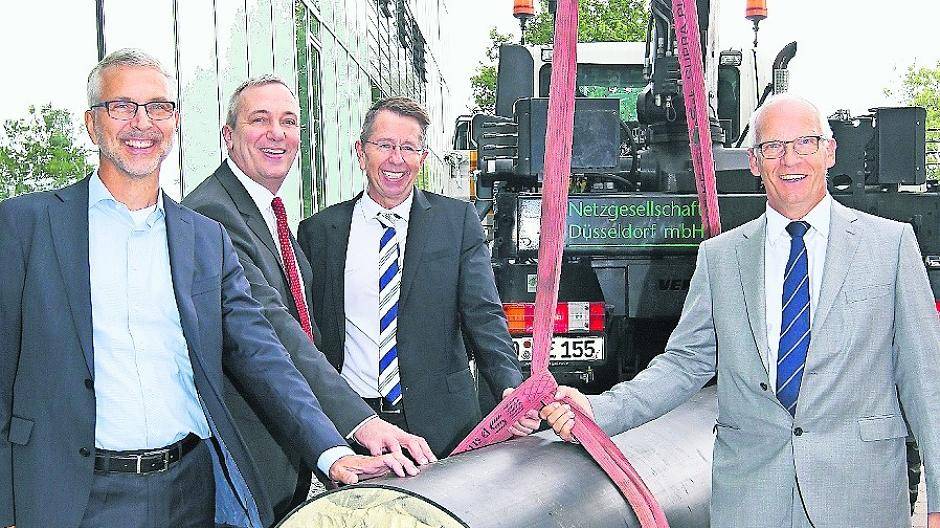  Gerhard Hansmann (Geschäftsführer Netzgesellschaft Düsseldorf mbH), Dr. Udo Brockmeier (Vorstandsvorsitzender Stadtwerke), Holger Odenthal (Stellvertretender Leiter Amt für Verkehrsmanagement der Stadt) und Michael Hanné (Flughafengeschäftsführer mit einer Fernwärmerohr. 