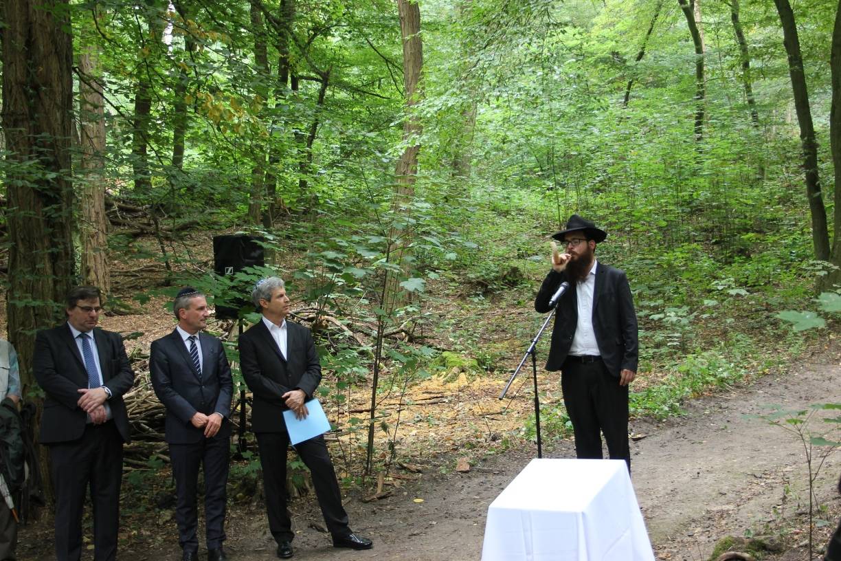  Rabbiner Levy Hefer (r.) bläst den Schofar, das traditionelle Widderhorn, bei der Zeremonie vor dem jüdischen Friedhof im Gerresheimer Wald an der Quadenhofstraße, während Karsten Kunert, OB Thomas Geisel und Oded Horowitz (v.l.) zusehen. 