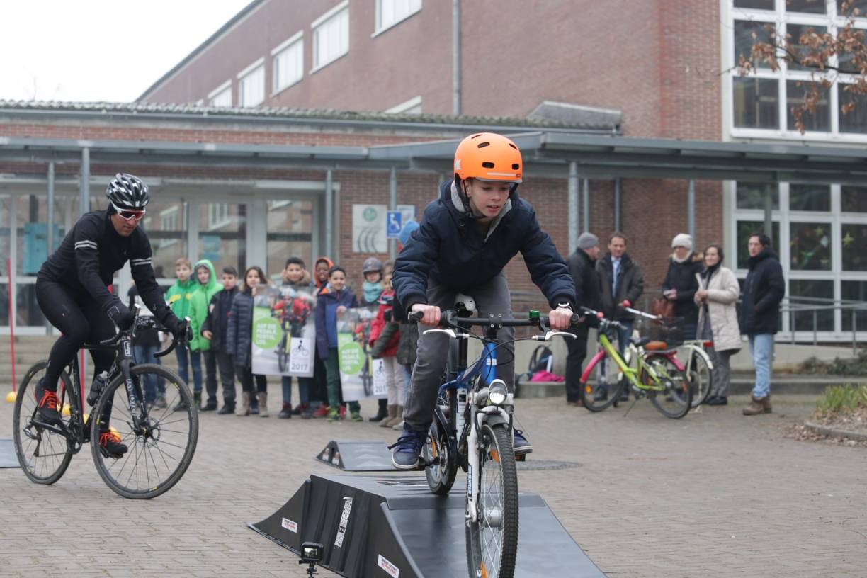  Sven Teutenberg und ein Schüler der Hulda-Pankok-Gesamtschule geben auf einem Hindernisparcours einen Vorgeschmack auf den Petit Départ. 