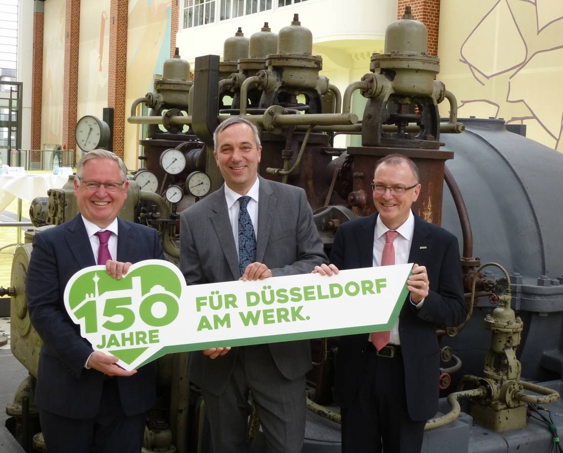  Vertriebsvorstand Manfred Abrahams (von li.), der Vorstandsvorsitzende Dr. Udo Brockmeier und Hans-Günther Meier, Vorstand Personal und Finanzen, beim Pressegespräch in der Turbinenhalle der Stadtwerke. Fürs Foto präsentieren sie das Jubiläums-Logo, das die Düsseldorfer Silhouette in einem Herz zeigt. 