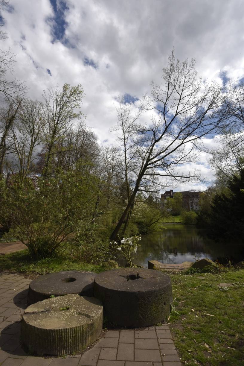  Blick auf Mühlsteine und den kleinen Park vor der Mühle. 