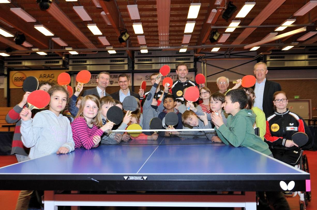  "CHECK!" soll die Kids der Stadt, hier Drittklässler der Rochusschule, für Sport begeistern. Unter anderem mit am Tischtennistisch: OB Thomas Geisel, Prof. Dr. med. Karsten Müssig und Borussia-Coach Danny Heister (hinten, v. l.). 