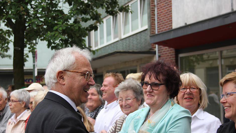 Pfarrer Karl-Heinz Süzenfuß begrüßt am Straßenrand Menschen, die ihm zugewunken...
