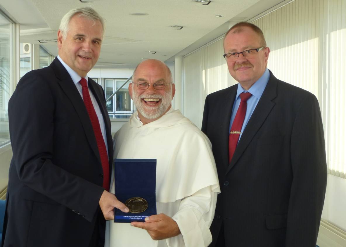  Freut sich riesig über die Jakob Faasen-Plakette: Dominikaner-Pater Wolfgang Sieffert, mit Kreissparkassen-Chef Johann-Peter Ingenhoven (li.) und dem neuen Bilker Schützen-Chef Ulrich Müller. 