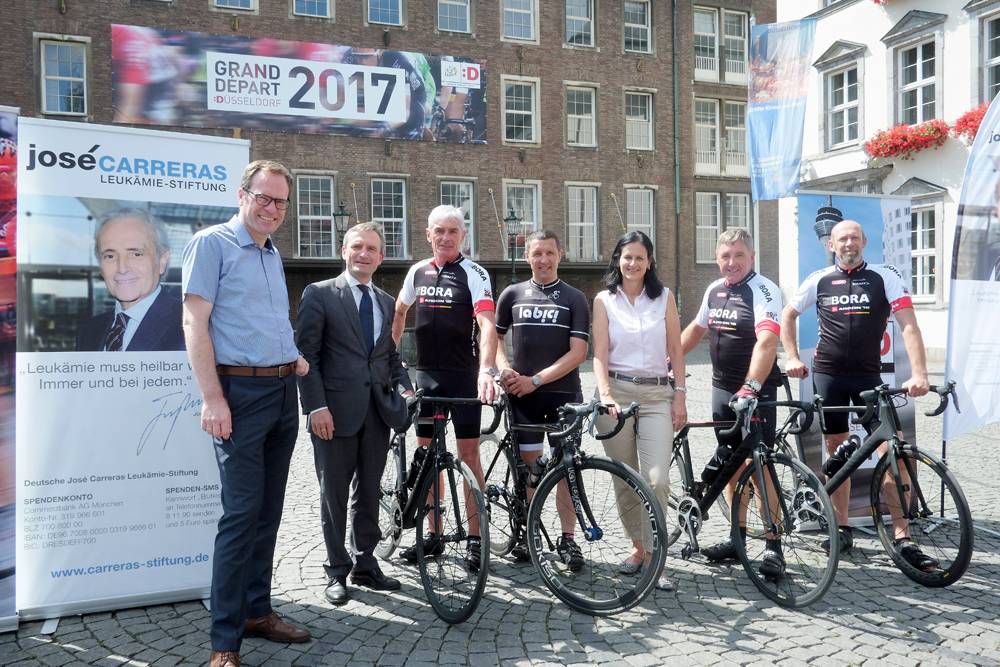  Dr. Stephan Keller (l.) und OB Thomas Geisel (2. v. l.) verabschieden die Radsportler mit Dr. Gabriele Kröner auf dem Marktplatz. 