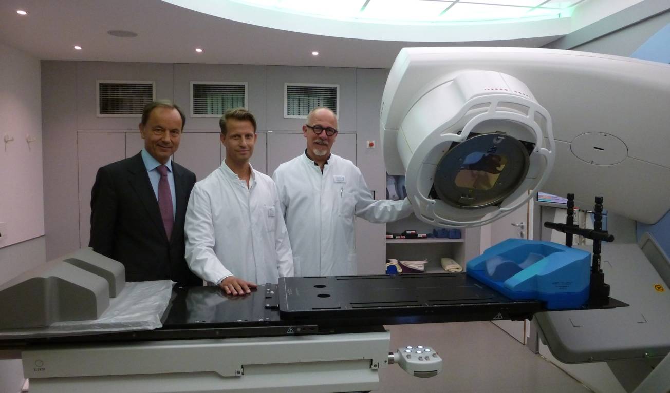  EVK-Chefarzt Prof. Dr. Horst Neuhaus (v. li.), Dr. Henning Bredenfeld, Leiter der onkologisch-strahlentherapeutisch ausgerichteten Großpraxis am EVK und Dr. Johannes von der Haar, Leiter der Strahlentherapie, mit dem neuen Linearbeschleuniger. 