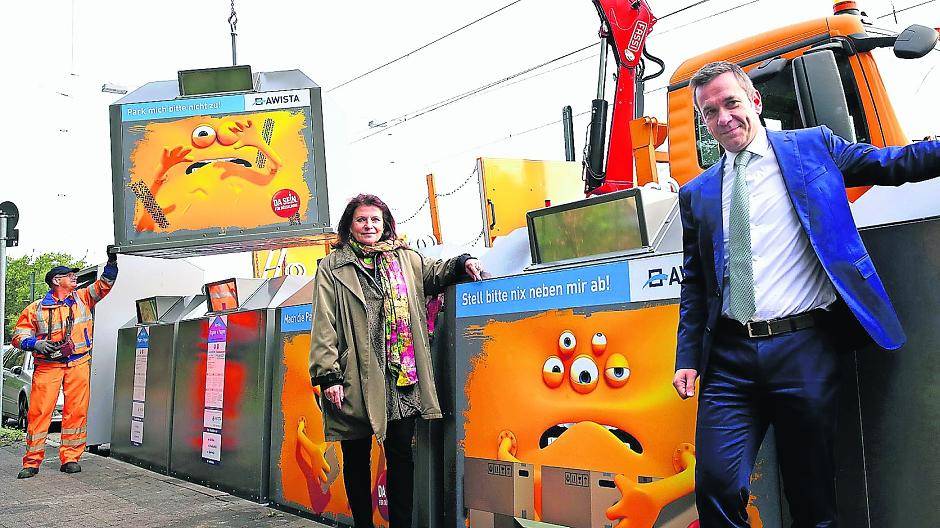  Umweltdezernentin Helga Stulgies und Awista-Geschäftsführer Björn Becker stellen die Containermonster-Kampagne an der Ulmenstraße vor. Marek Krzyzaniak von der Awista (l.) bringt die neuen Container in Position.  