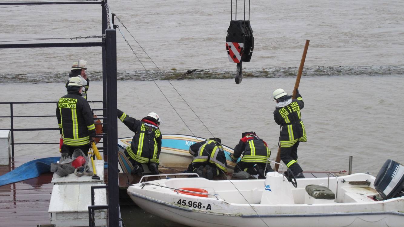  Die Einsatzkräfte bergen das gesunkene Boot aus dem Rhein. 