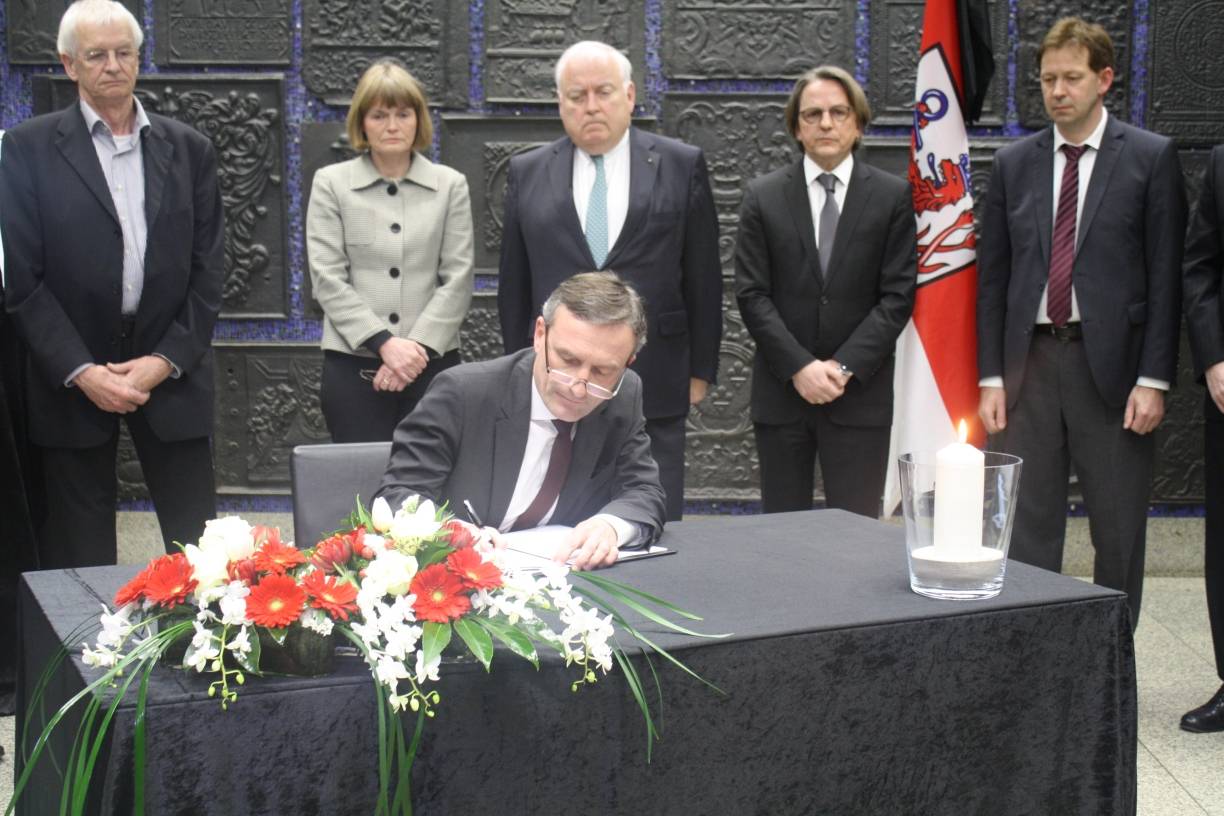  Oberbürgermeister Thomas Geisel schreibt als Erster ins Kondolenzbuch im Rathaus. Dahinter stehen (v. l.) die Bürgermeister Günter Karen-Jungen, Klaudia Zepuntke, Friedrich Conzen sowie die Beigeordneten Gregor Bonin und Burkhard Hintzsche.  