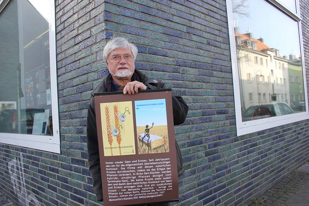  Werner Burkard mit einem seiner Plakate, die eine ganze Weile in den beiden Schaufenstern der Stadtbücherei Heyestraße hingen und für viel Aufmerksamkeit sorgten. 