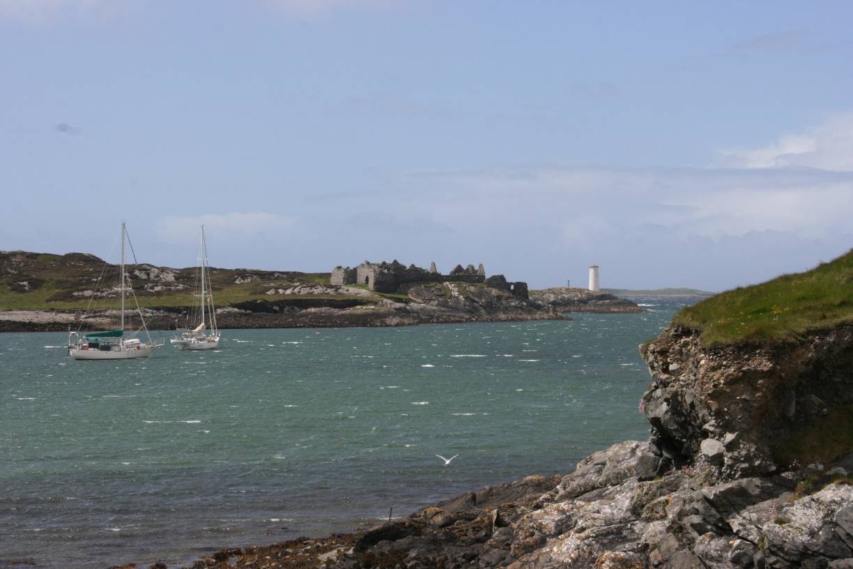  Der weiße Leuchtturm und die Festungsruine - die Hafeneinfahrt von Inishbofin. 