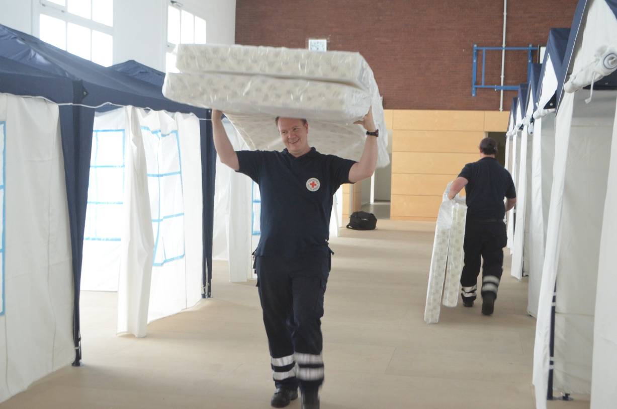  Thorsten Pasch (l.) und Thomas Winter vom Deutschen Roten Kreuz statten die Turnhalle des Leo-Statz-Berufskollegs in Bilk für Flüchtlinge mit Zeltpavillons und Betten aus. 