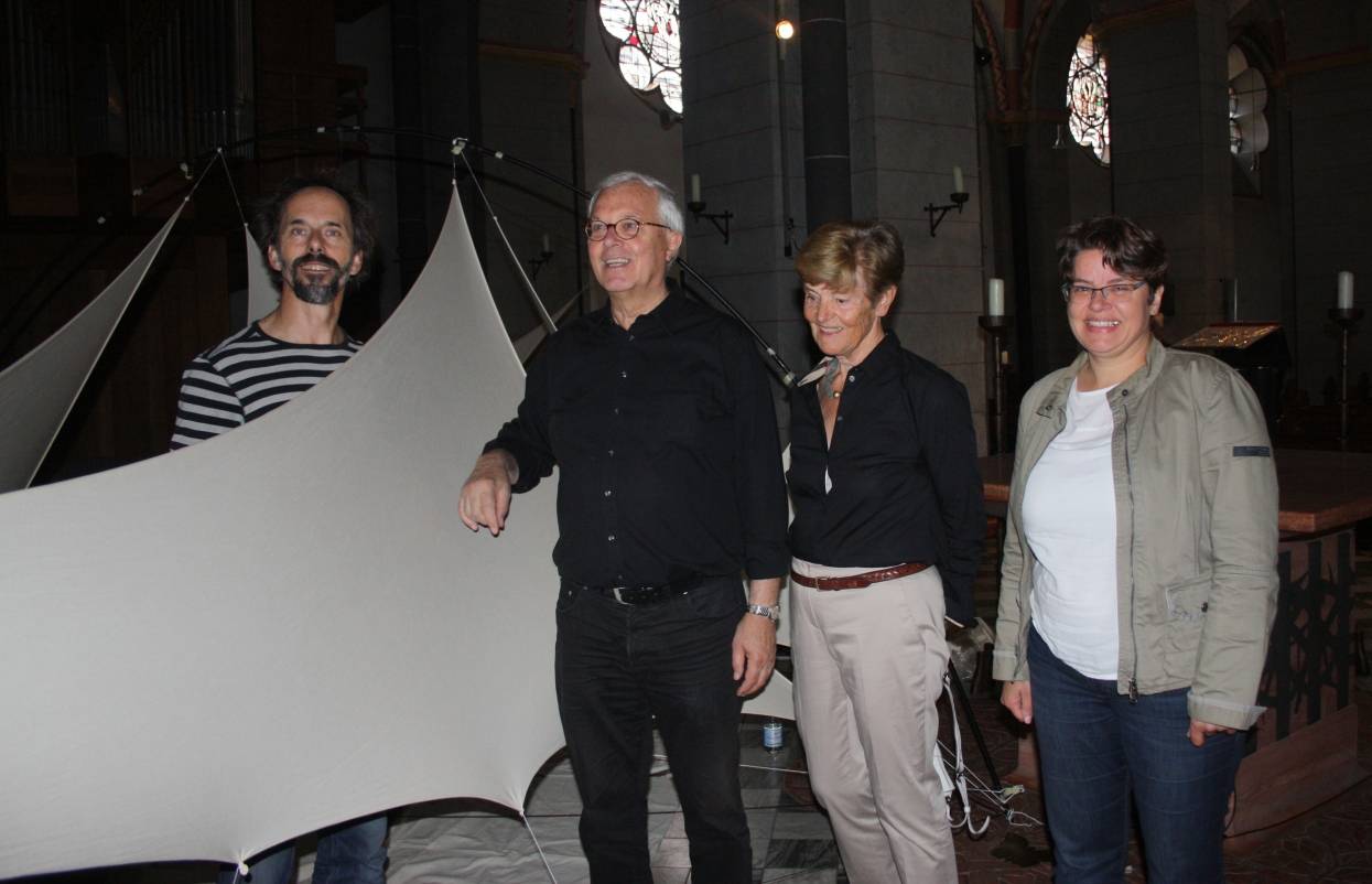 Künstler Jens J. Meyer (li.) baut im Altarraum seine Installation zusammen. Gastgeber Pastor Karl-Heinz Sülzenfuß, Sigrid Hirsch und Dr. Beate Johlen-Budnik schauen interessiert zu. 