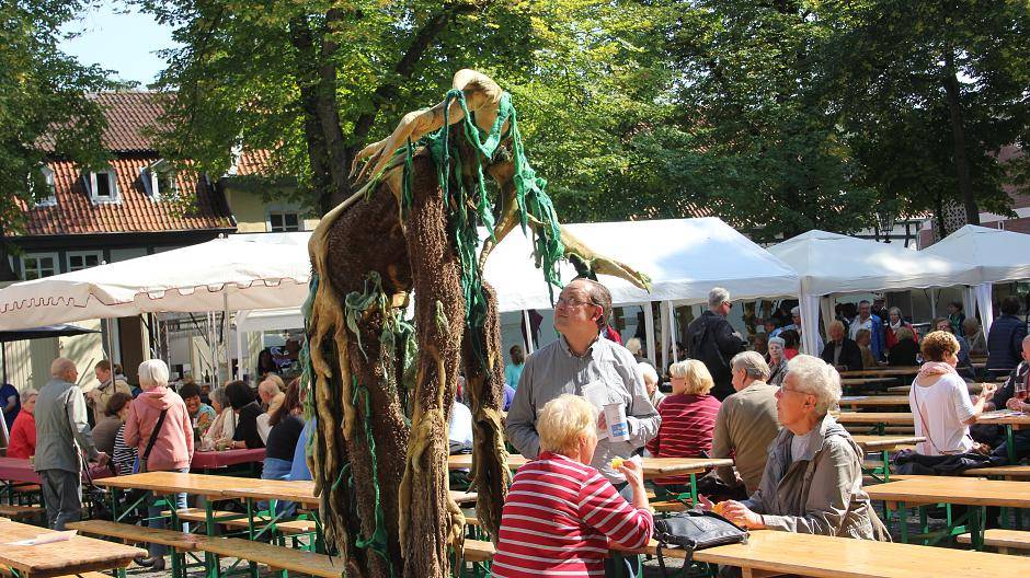 Die überdimensionale Weinrebe stakst über den Platz und streichelt hier Stefan Jansen...