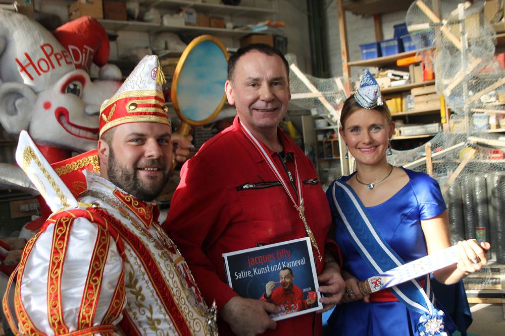  Jacques Tilly (m.) mit dem neuen Bildband über seine Arbeit. Bei der Buchvorstellung schaute auch das aktuelle Prinzenpaar, Hanno I. und Venetia Sara, vorbei. 