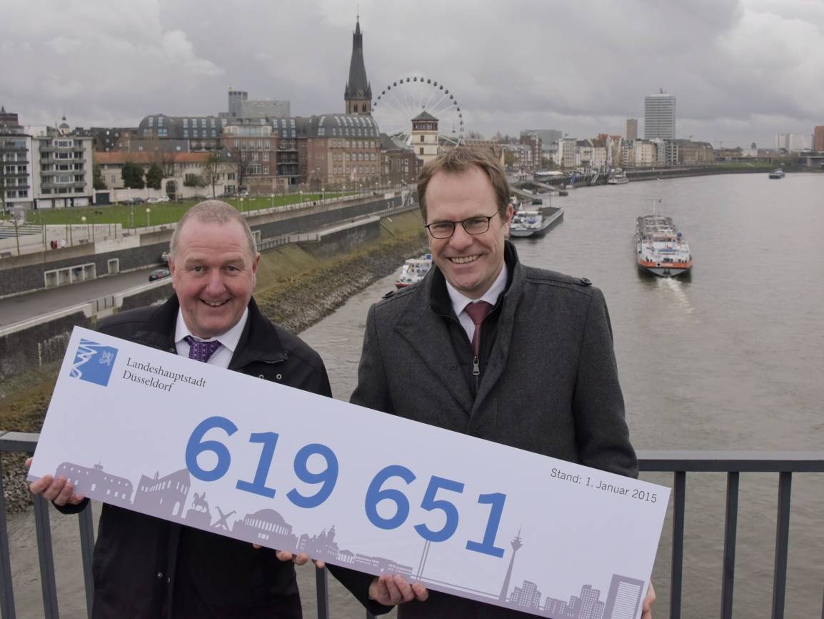 Der Beigeotdnete Dr. Stephan Keller (re.) und Wahlamtsleiter Manfred Golschinski präsentieren ein Schild mit der neuen offiziellen Einwohnerzahl.Foto: Landeshauptstadt Düsseldorf, Wilfried Meyer 