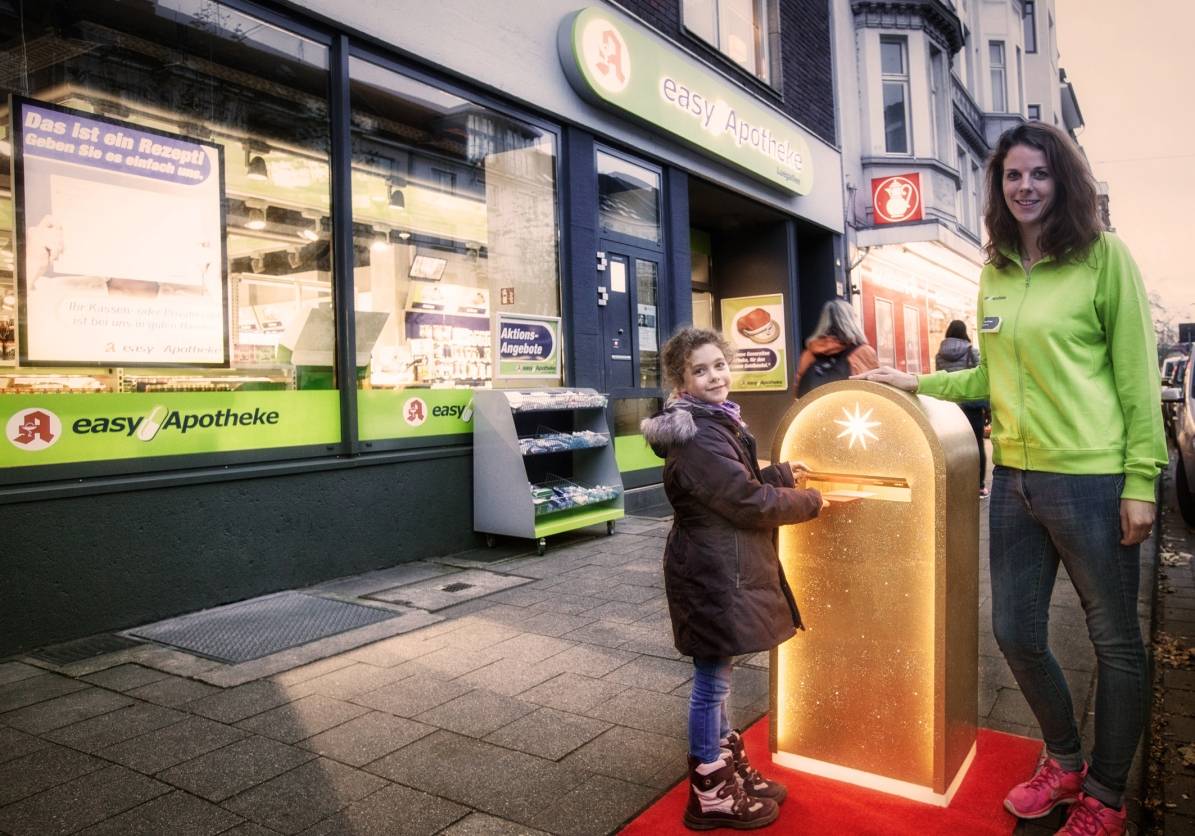 Christkind stellt goldenen Postkasten in Düsseldorf auf