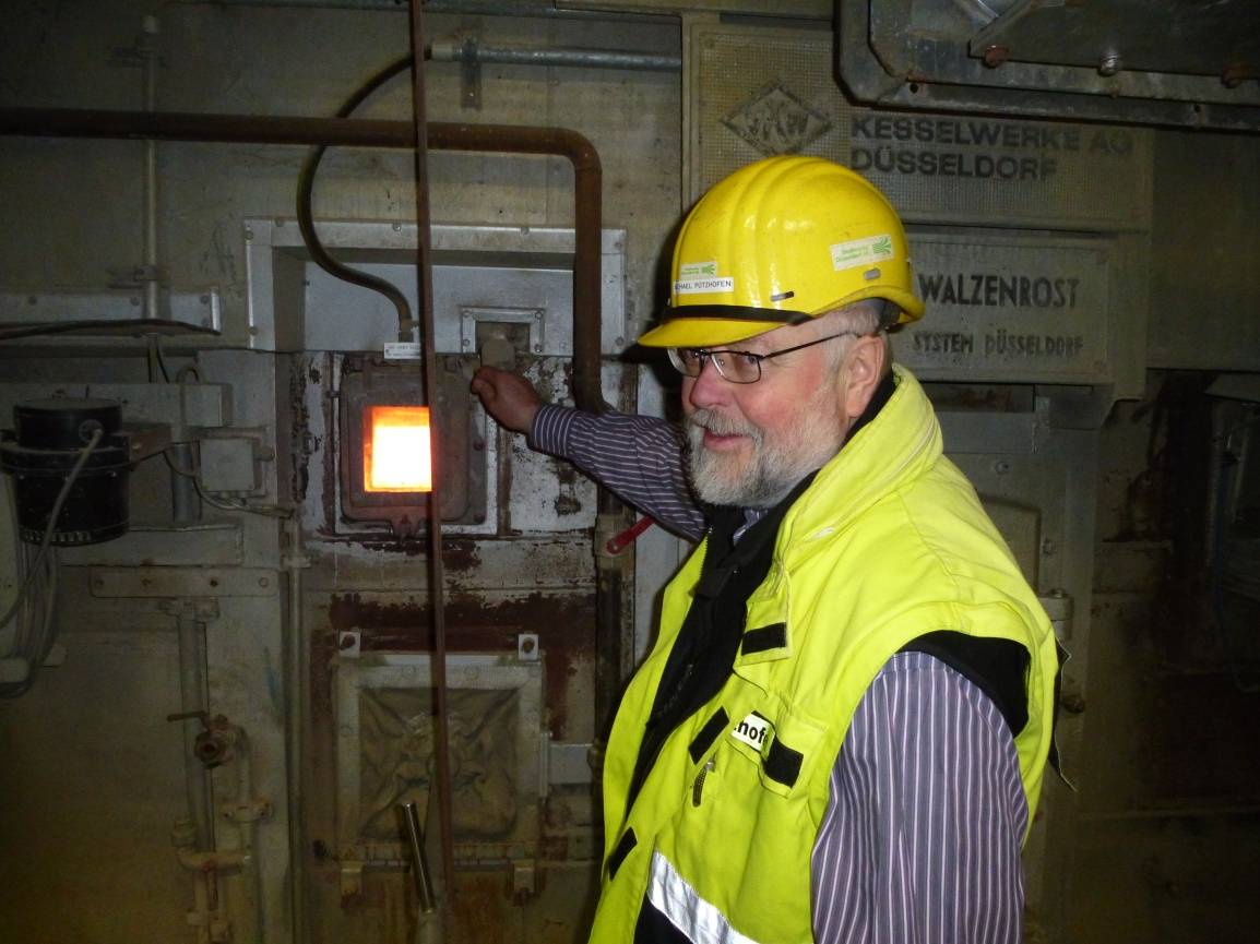  Hier ist es bereits sehr warm: Stadtwerke-Pressesprecher Michael Pützhofen öffnet das Sichtfenster zu einem der Kessel. Die Glasscheibe ist glücklicherweise sehr dick. Doch die Hitze ist spürbar. 