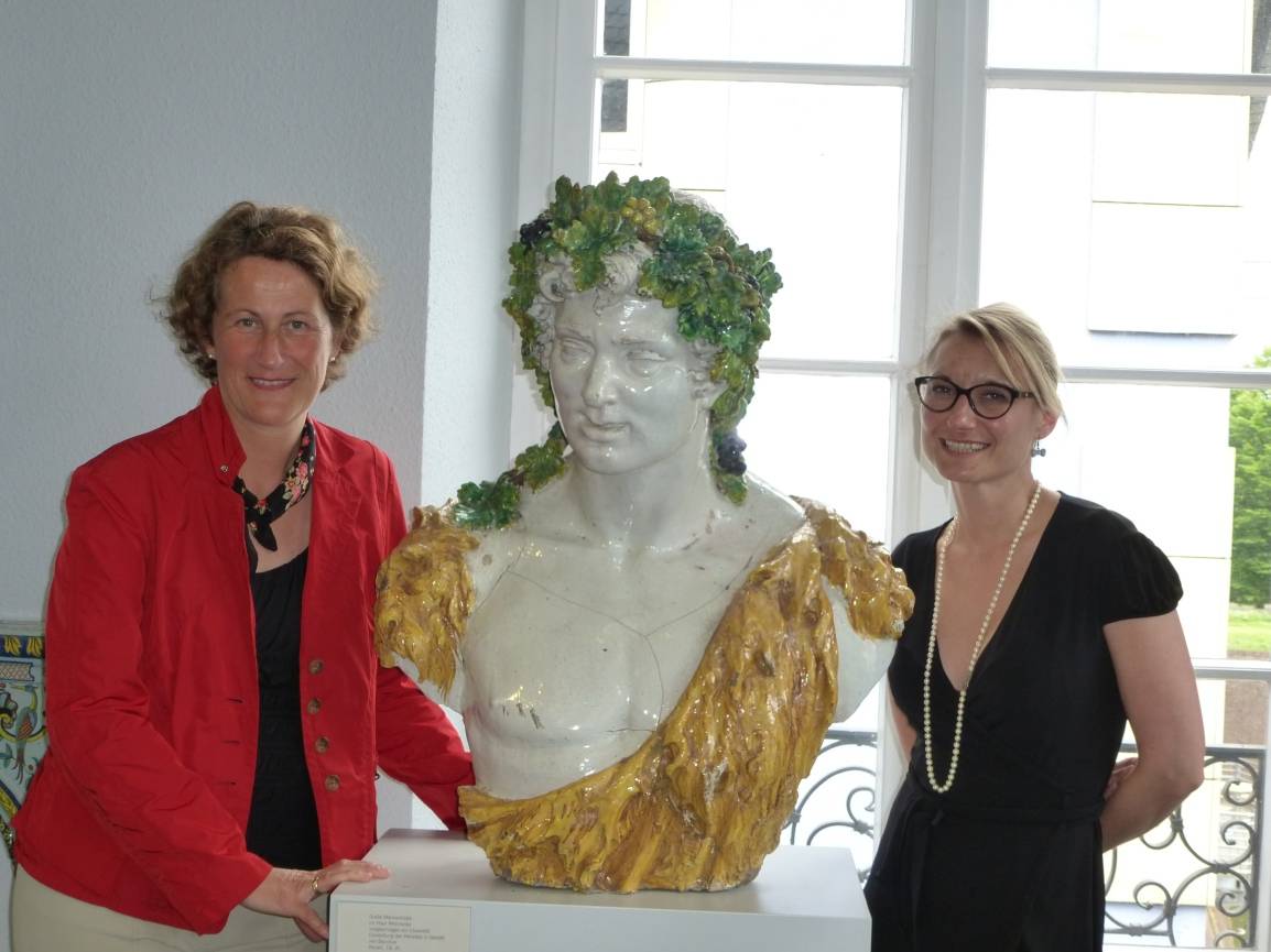  Stadtführerin Claudia Kuhs (li.) und Dr. Daniela Antonin, Stellvertretende Leiterin des Düsseldorfer Hetjens-Museums mit einer großen Bacchus-Büste aus dem 18. Jahrhundert. 