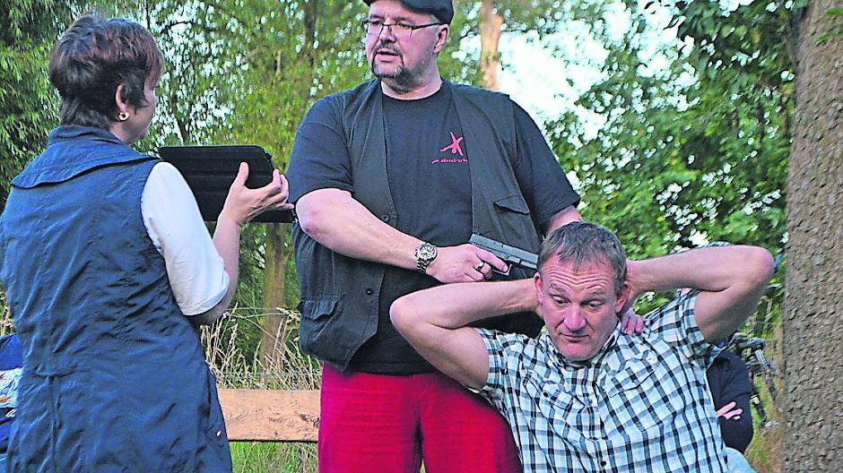  Jörg Marenski (Mitte) stellt die Schluss-Szene seines Romans in der Urdenbacher Kämpe nach und liest aus seinem Krimi. Teilnehmer Torsten Luckow (r.) muss als bedrohte Hauptfigur Kommissar Oberle herhalten. 