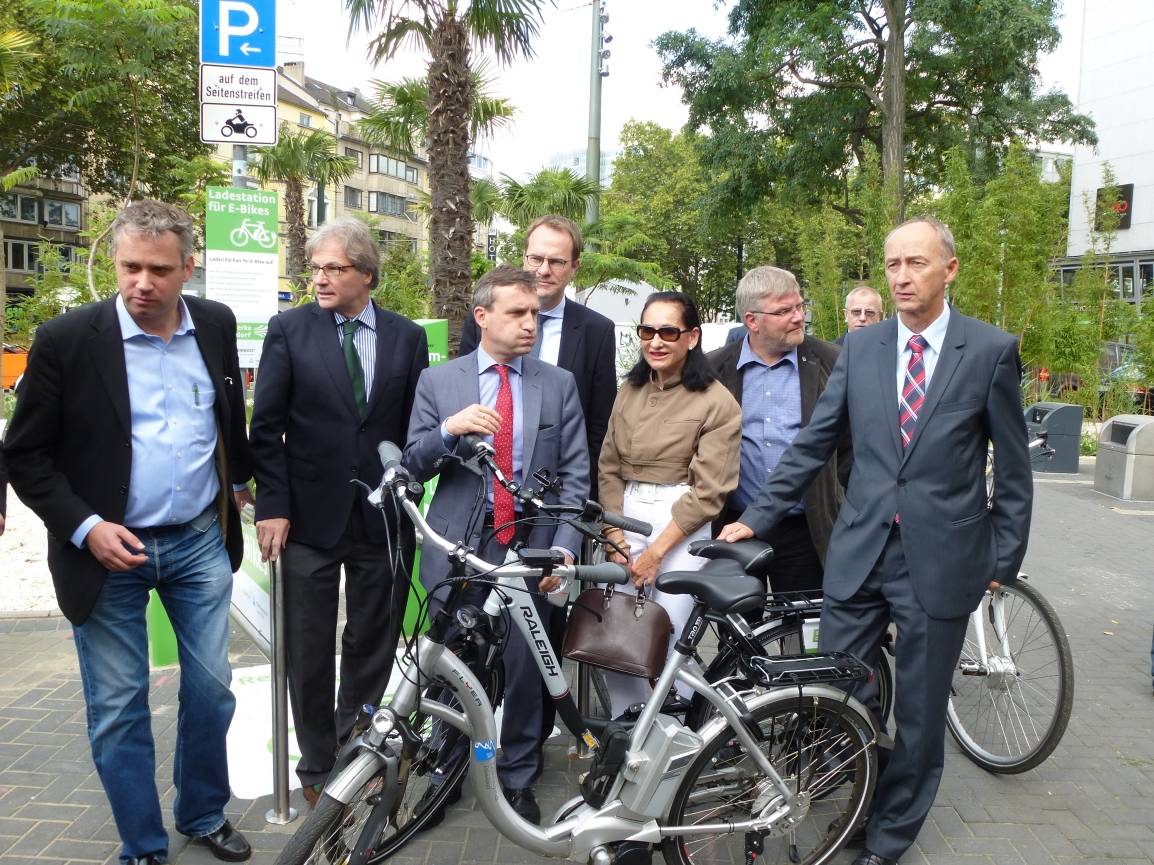  Gruppenbild mit Palme und Fahrrad: In der Mitte OB Thomas Geisel und Tita Giese, rechts Rainer Pennekamp von den Stadtwerken. Vorne: Das E-Bike vom OB. 