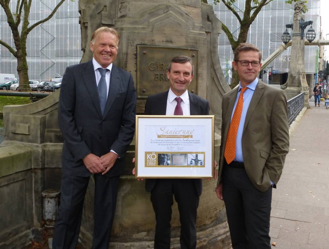  Peter Wienen (li.) und Hans Paffrath vom Förderverein Kö Kulturerbe e.V. überreichen Oberbürgermeister Thomas Geisel ein besonderes Geschenk. 