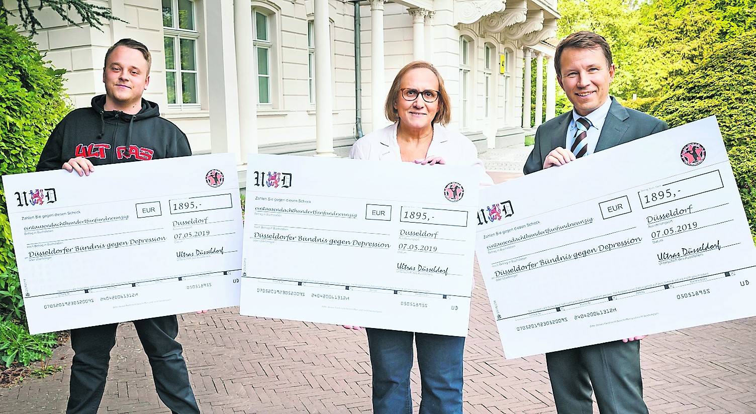 Marco Vorderstemann (l.), Vorstandsmitglied des Supporters Club Düsseldorf, überreichte die Spende an Dr. Viktoria Toeller, Geschäftsführerin des Düsseldorfer Bündnisses, und Prof. Dr. Tillmann Supprian, stellvertretender Vereinsvorsitzender des Bündnisses.