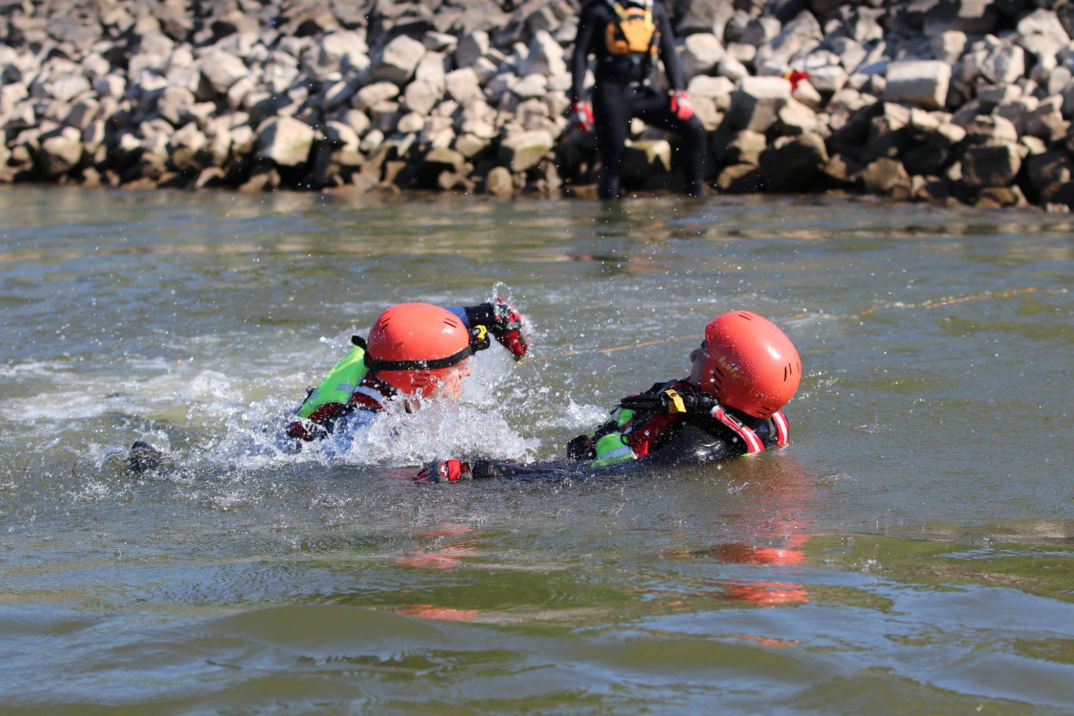  Bei einer Übung im Rhein schwimmt ein Strömungsretter (links) der Taucherstaffel zu der in Not geratenen Person, um diese so schnell wie möglich zu sichern und ein Untergehen zu verhindern. 