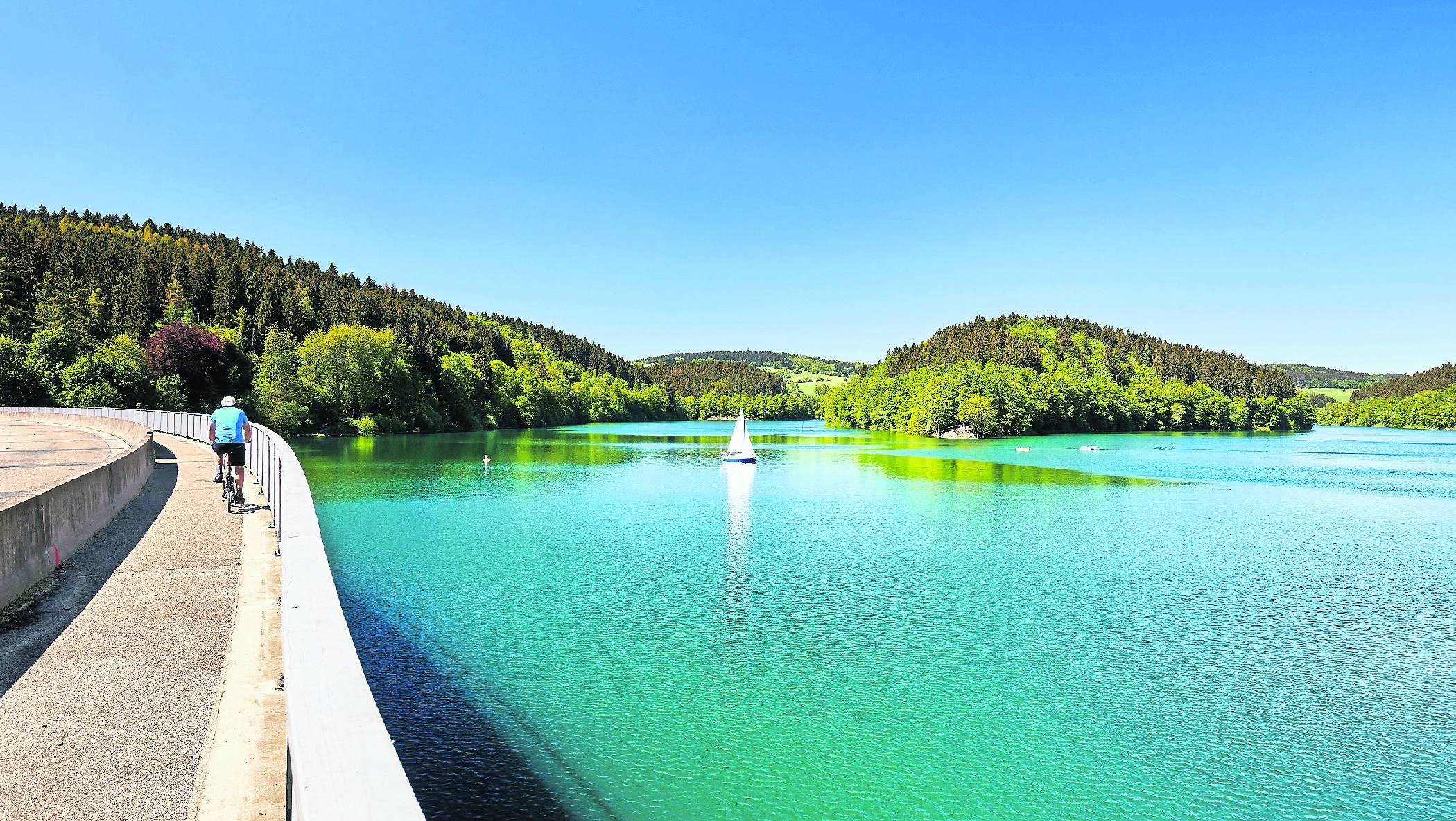 Der Bergische Panorama-Radweg führt über die imposante Aggertalsperre am spiegelglatten Stausee entlang.