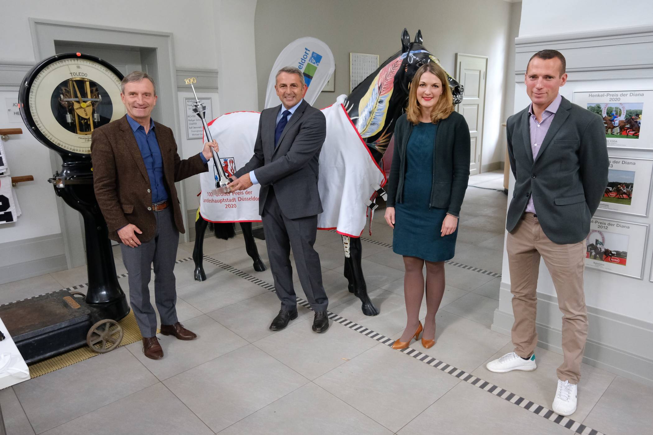  OB Thomas Geisel (l.) und Klaus Allofs, Vorstand des Reiter- und Rennvereins, präsentieren mit Geschäftsführerin Andrea Höngesberg und Champion-Trainer Henk Grewe den Rheinturm für den 100. Gewinner des Traditions-Rennens. 