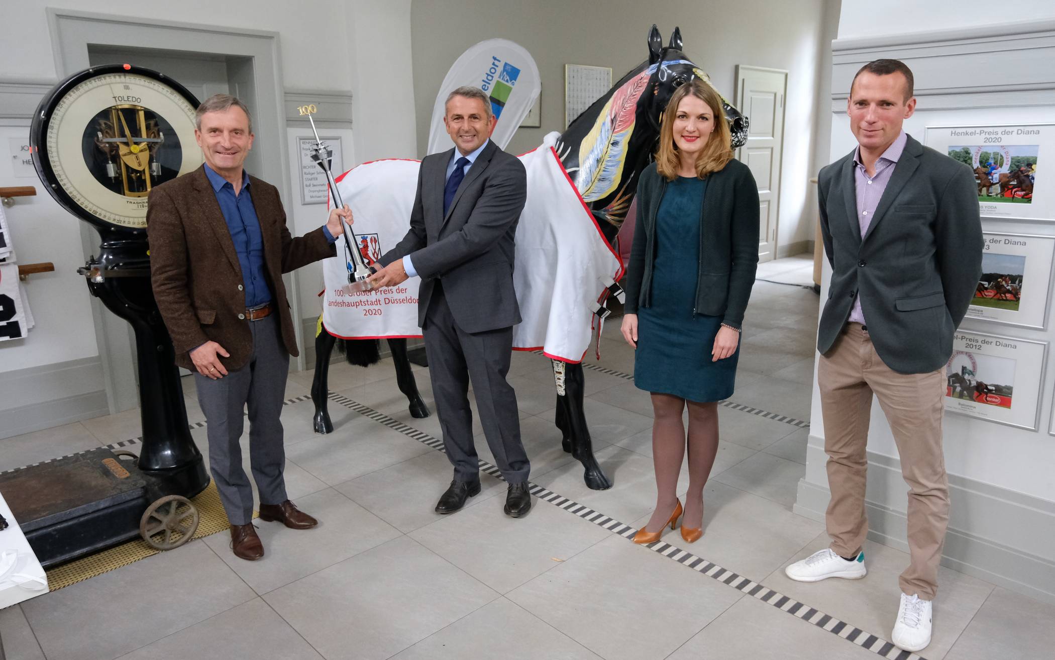  OB Thomas Geisel (l.) und Klaus Allofs, Vorstand des Reiter- und Rennvereins, präsentieren mit Geschäftsführerin Andrea Höngesberg und Champion-Trainer Henk Grewe den Rheinturm für den 100. Gewinner des Traditions-Rennens. 