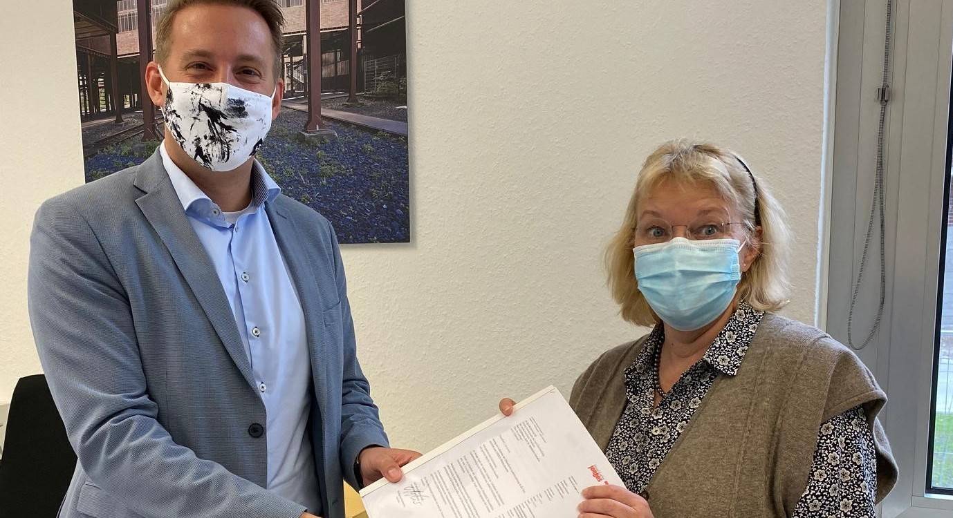  Carolyn Eickelkamp von der Initiative Düsseldorfer Gaslicht übergibt die Bewerbung an Ministerialrat Dipl.-Ing. Thomas Schürmann, Referatsleiter für Denkmalschutz und Denkmalpflege im Heimatministerium NRW.  